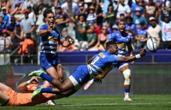 A Stormers player dives to catch the ball during a thrilling rugby match, showcasing athleticism and determination.